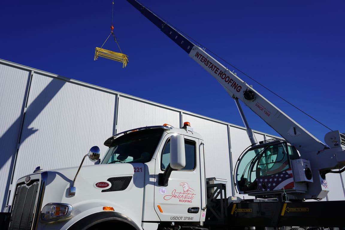 Interstate Roofing crane truck on a project site